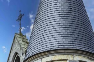 CLose up image of tiles placed on a curved roof steeple