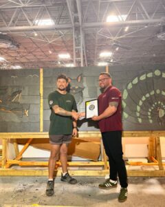 Winner of the Great British Slate Off 2026 - Josh Williams, 1st Choice Roofing shaking hands with Dan Edwards of SIG Roofing